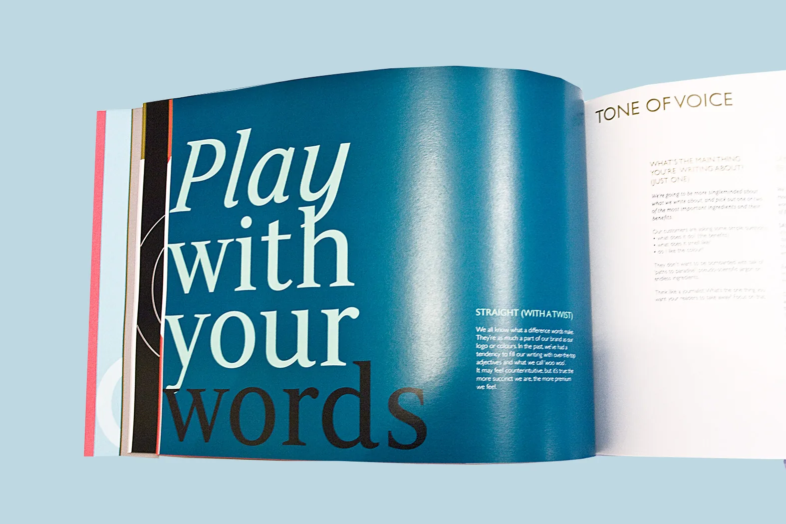 Premium perfect-bound brand guidelines book by City Images: full-bleed teal Play With Your Words spread, tone-of-voice page detail.