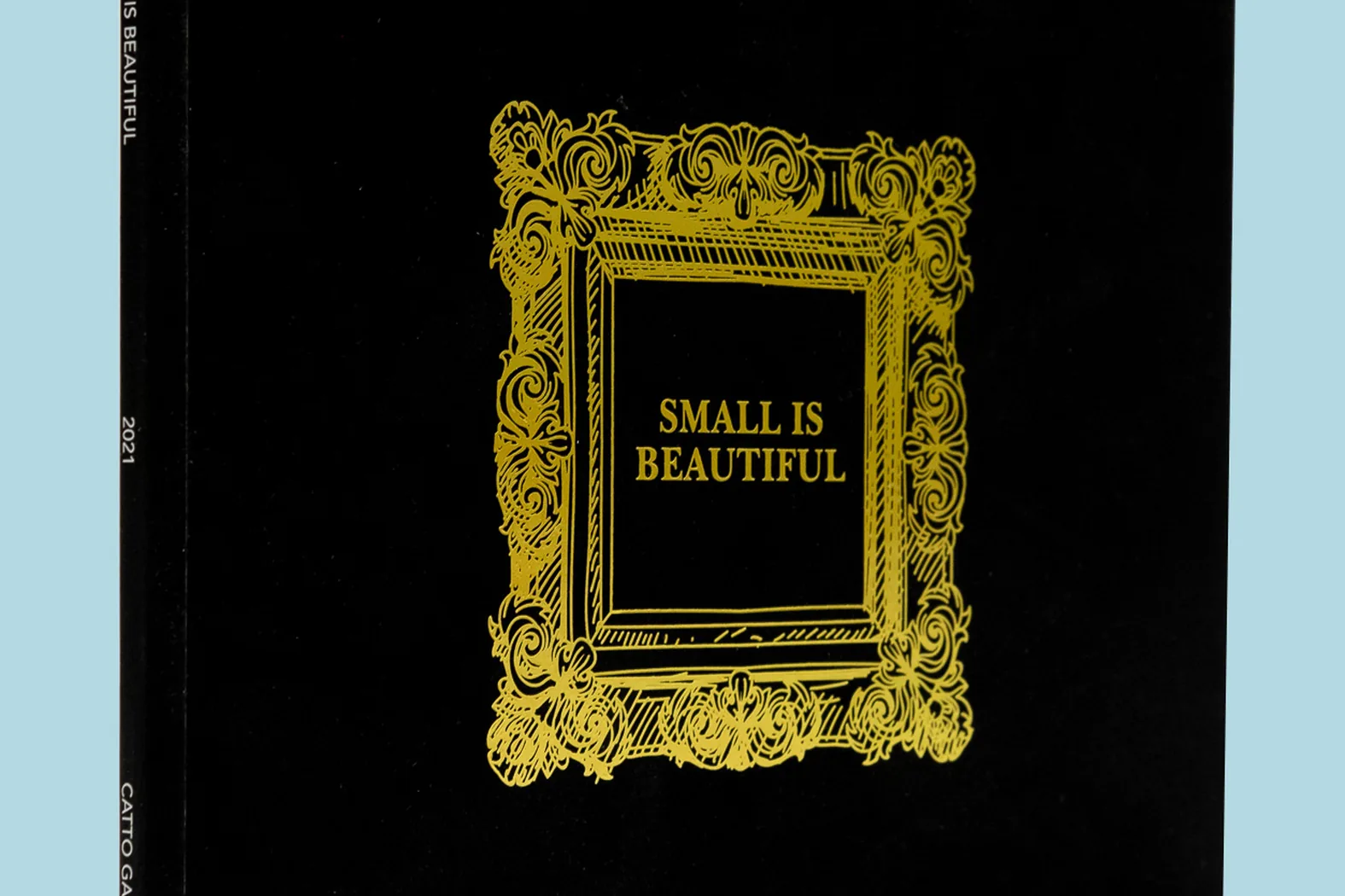 Perfect-bound art catalogue by City Images: black cover with gold foil-blocked ornate frame and gallery exhibition title.