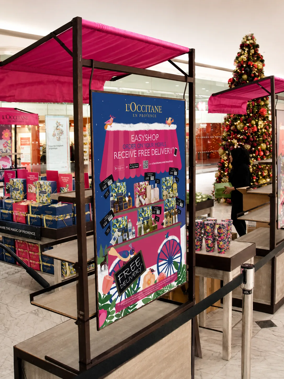L'Occitane EasyShop campaign poster in a Christmas market-stall retail display, printed by City Images