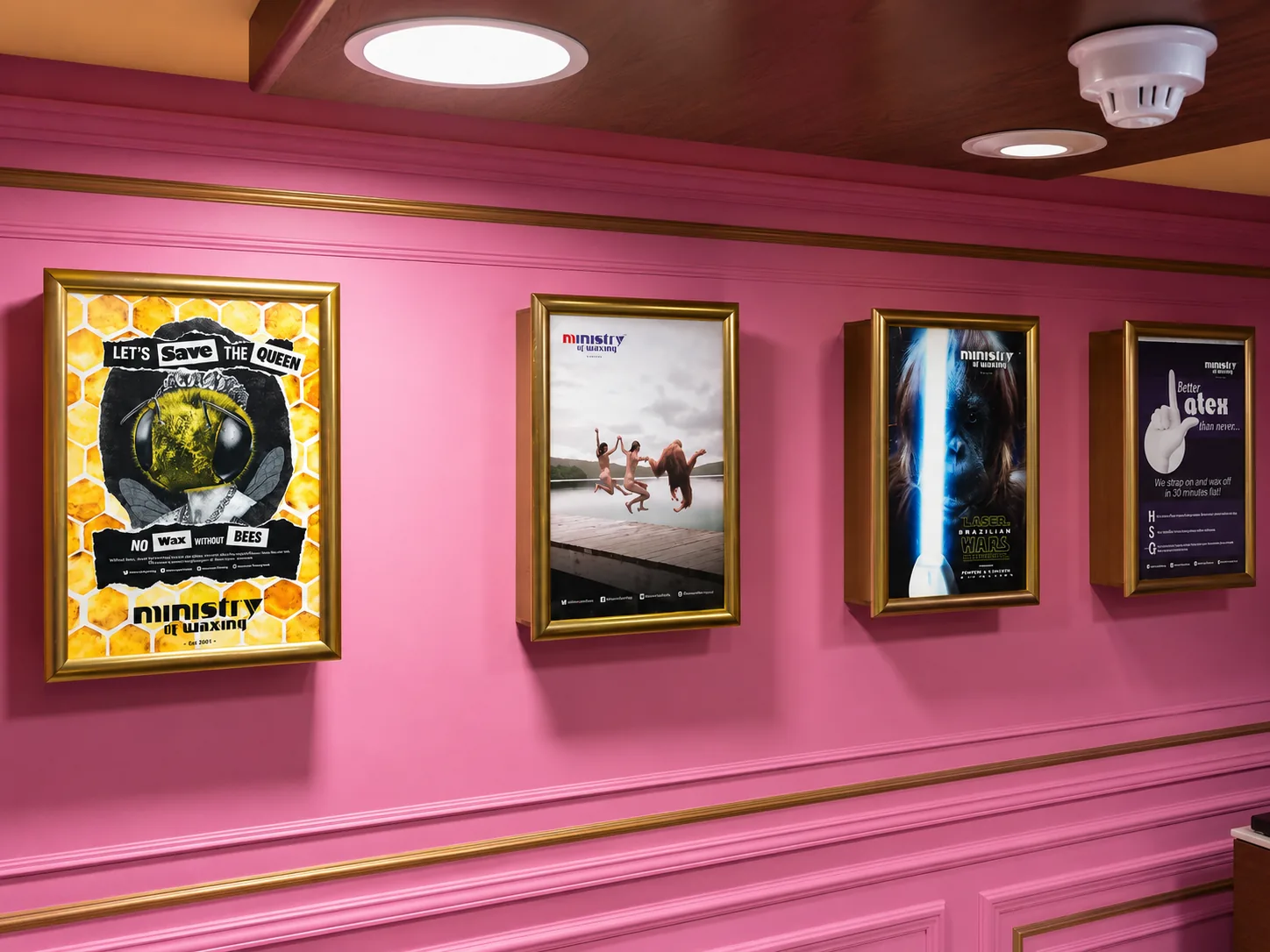 Four framed concert posters on a pink cinema lobby wall, printed by City Images