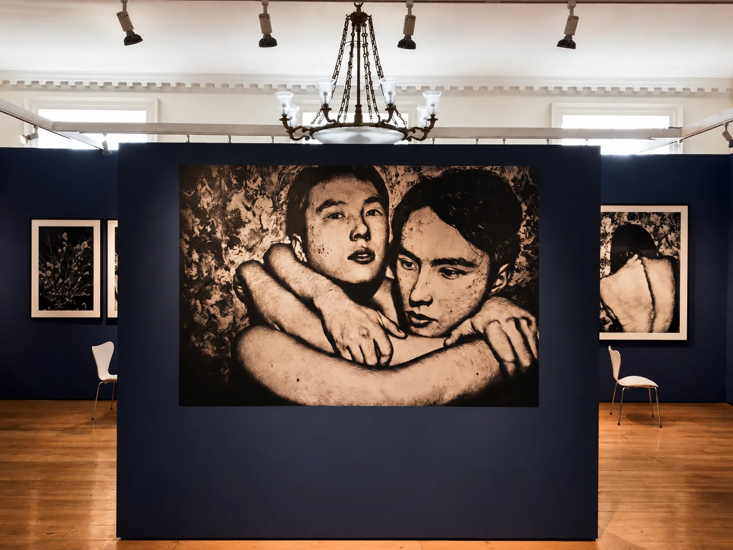 Large monochrome portrait poster install in a navy gallery with classical chandelier, City Images