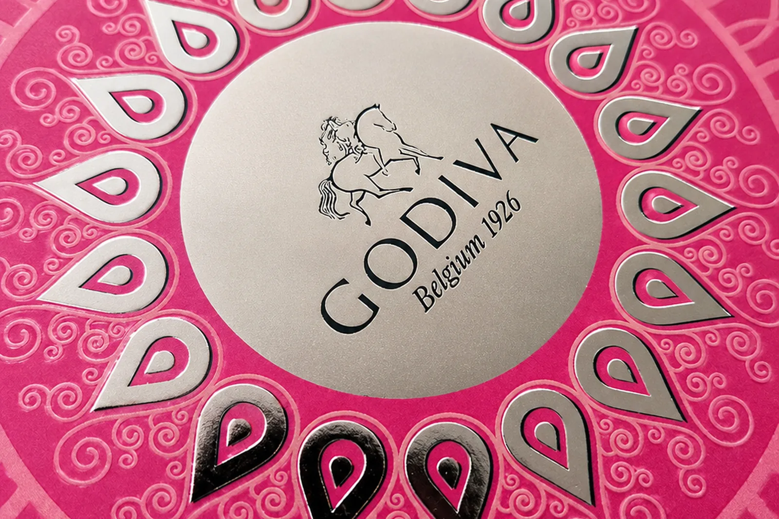 Silver foil and white-on-pink luxury chocolatier packaging with mandala motif