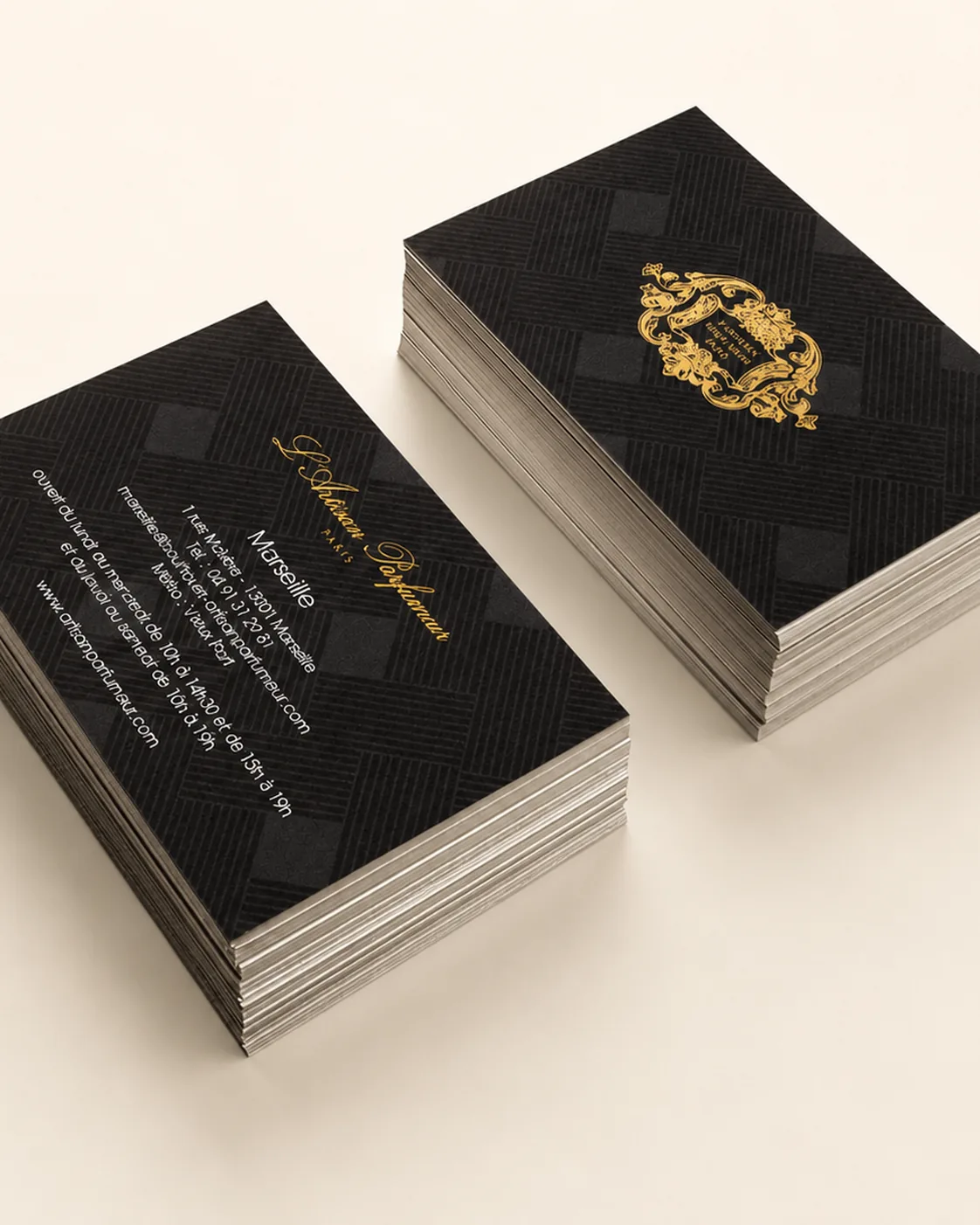 Stack of 550gsm Colorplan business cards with hot-foil gold heraldic crest, side angle showing duplex weight