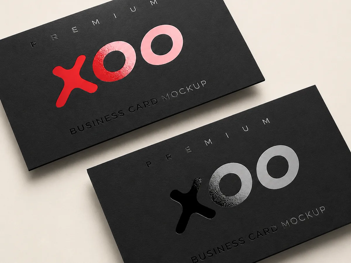 Two matt black business cards with spot UV gloss raised typography in red, demonstrating the gloss-on-matt finish