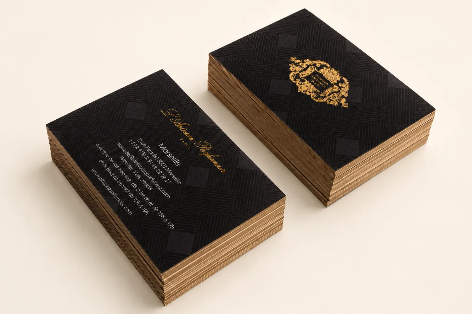 Top-down stack of black 550gsm cards with traditional hot-foil gold heraldic crest, finished in-house at Camden