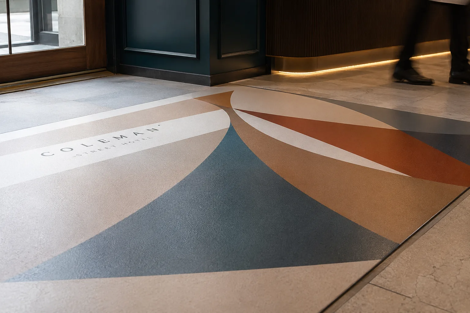 Coleman entrance with curved geometric floor graphic in slate and rust